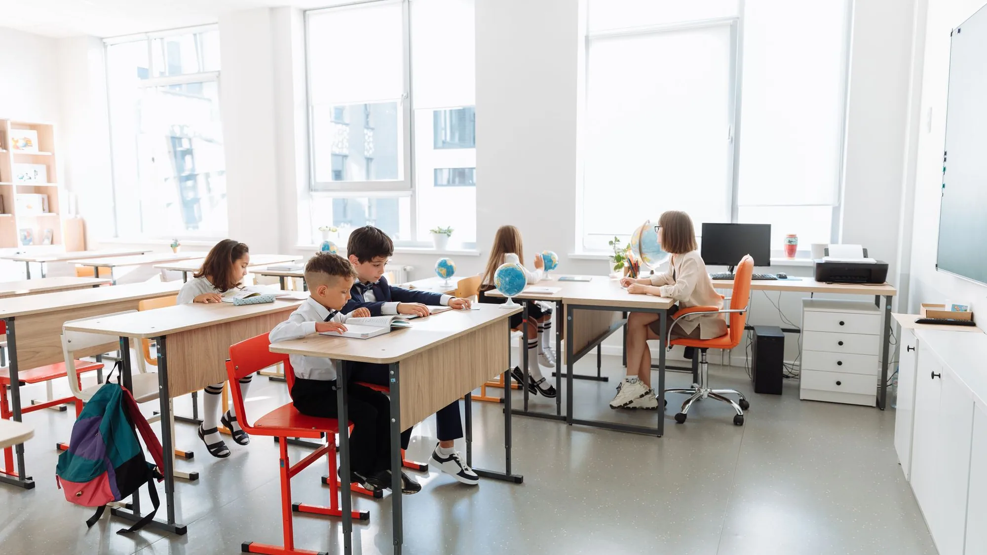 Klaslokaal met grote ramen waar leerlingen aan het werk zijn